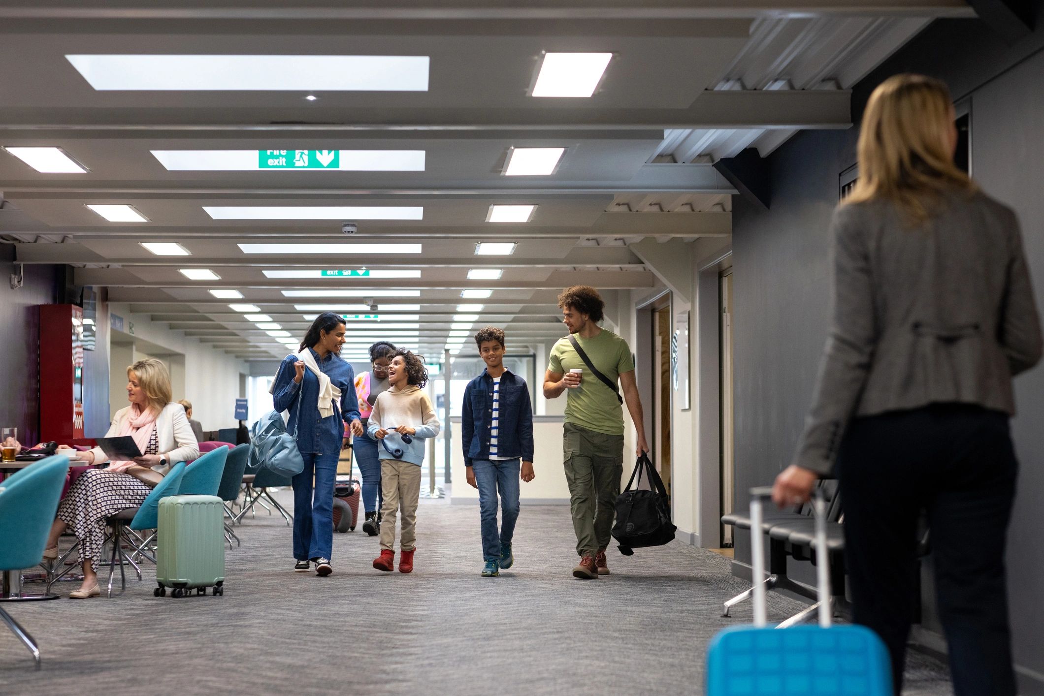 Family walking through an airport terminal with luggage